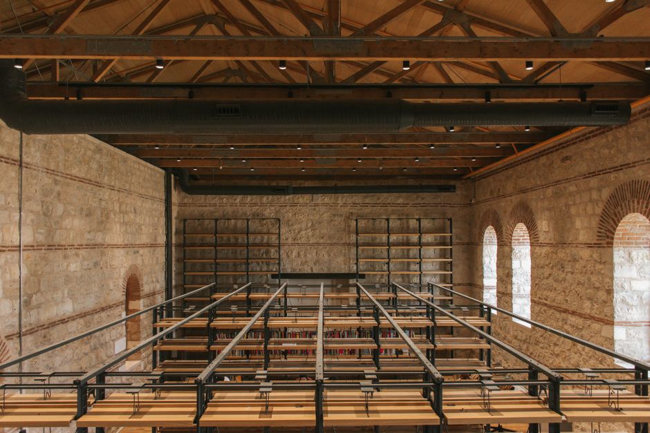 Vintage library interior with wooden beams and brick walls, showcasing a unique rustic design.