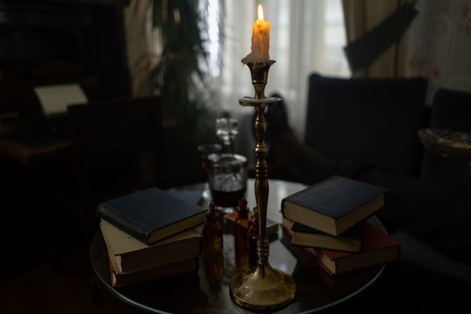 A cozy indoor scene with stacked books and a candle, creating a warm and inviting atmosphere.