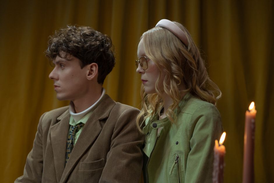 A sophisticated couple dressed in vintage style with candlelight ambiance.