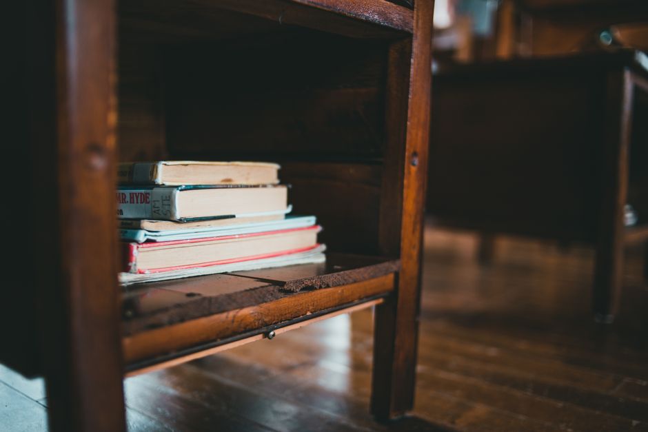 Closeup of a vintage wooden shelf with a stack of books, creating an educational and nostalgic feel.